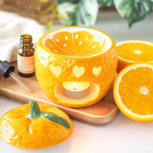 Quemador de aceite con forma de naranja recién cogida