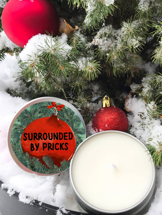 Vela perfumada navideña rodeada de plumas