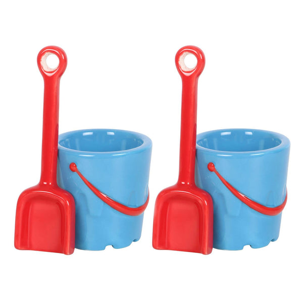 Set di 2 portauova in ceramica a forma di secchiello con cucchiai a forma di paletta