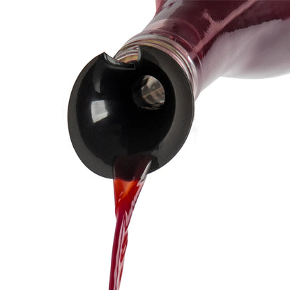 Red liquid pours from a tilted Count Corkula bottle with a black spout on a white background.