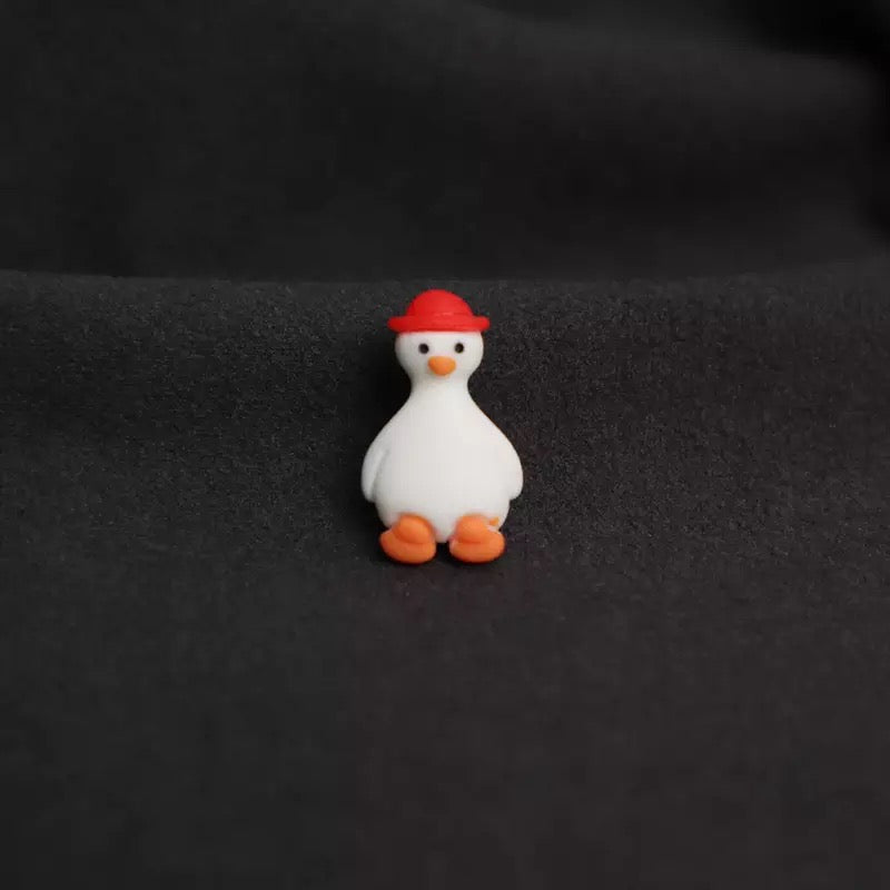 Spilla a forma di anatra bianca con cappello rosso